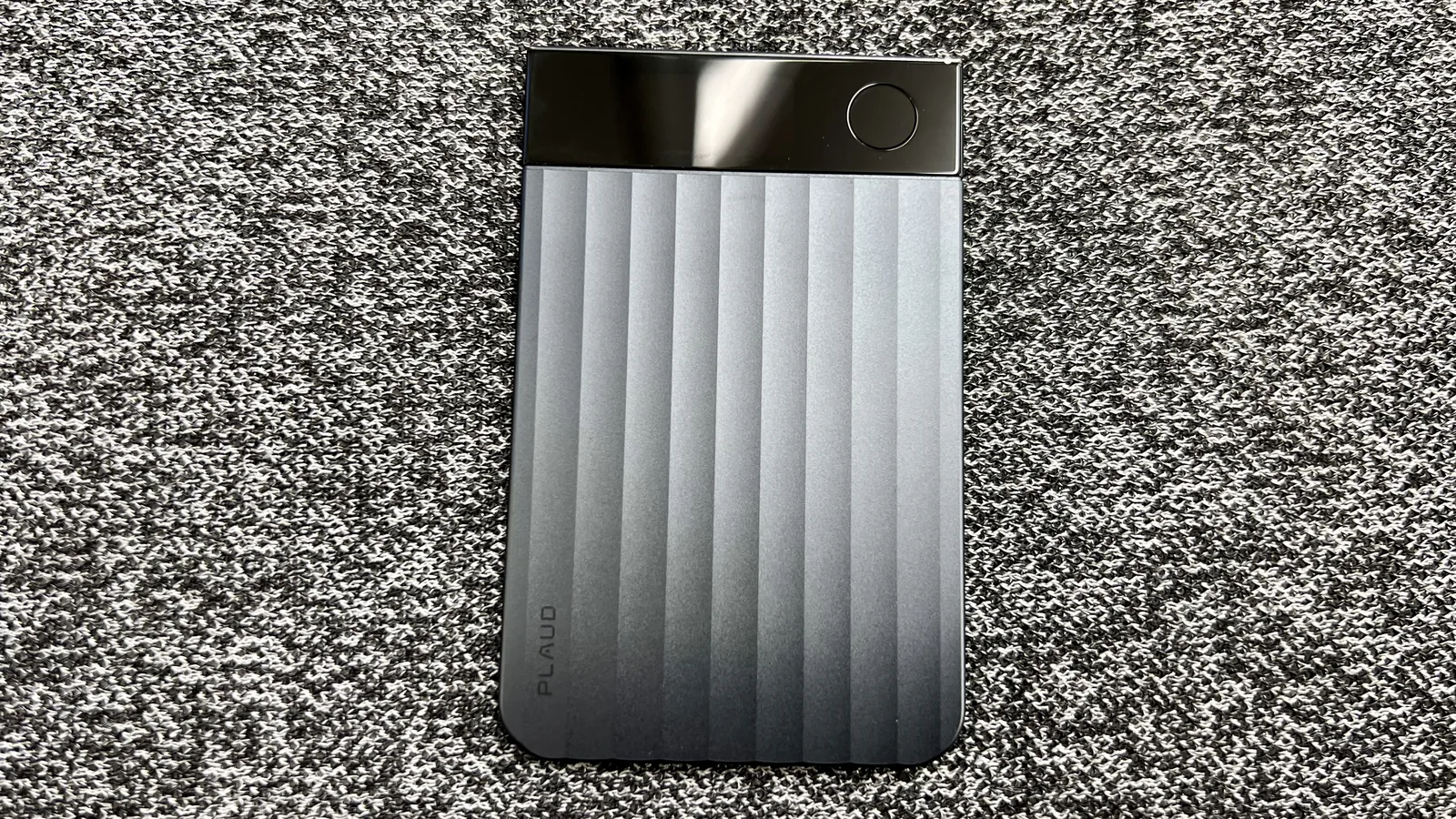 グレーの布地に置いたカード型PLAUD NOTE実機